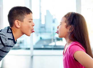 Children, fight or silly with tongue out, problem or frustrated with youth at home in living room....