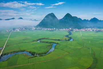 Aerial view of Bac Son valley with lush rice field and winding river. 