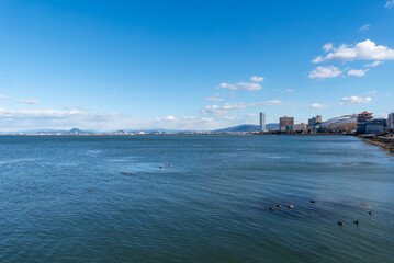 晴れた冬の日　青々とした空と琵琶湖　向こうに高層ホテルが立つ風景　滋賀県大津市