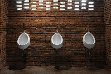 The row of white ceramic urinal chamber pot interior design with beautiful red brick wall panels...