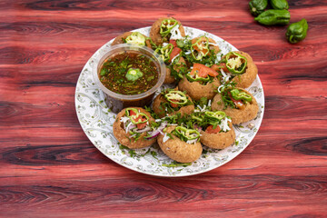Naga Fuchka, pan puri, or gol gappa filled with herbs with spicy water served in plate isolated on wooden table side view of bangladeshi street food © Food Shop