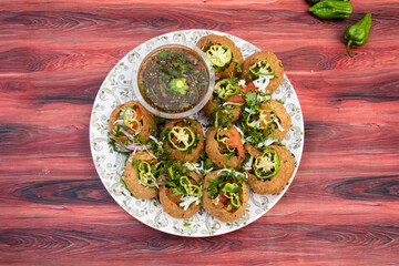 Naga Fuchka, pan puri, or gol gappa filled with herbs with spicy water served in plate isolated on wooden table top view of bangladeshi street food © Food Shop