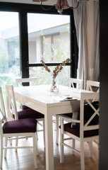 dining room with white and purple chairs with a glass vase as a centerpiece.