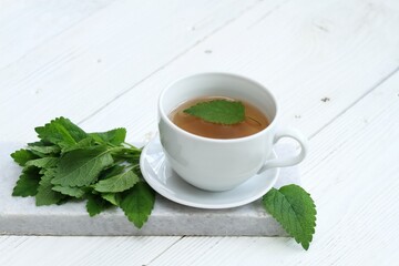 A cup of fresh tea from Melissa officinalis, commonly known as lemon balm or melissa. Balm tea is...