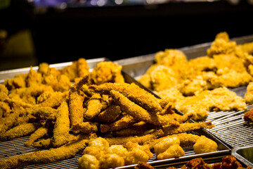  an array of golden, crispy fried foods including chicken, shrimp, and various other items arranged...
