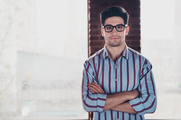 Photo of nice young corporate man crossed arms wear striped shirt loft interior office indoors