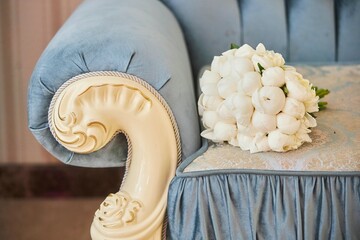 Decor for a wedding or engagement party. Wedding bouquet on a blue upholstered armchair