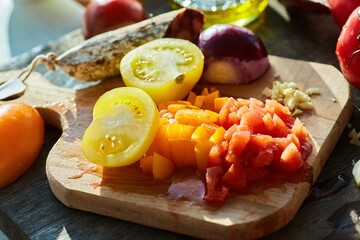 Step-by-step cooking process. Finely chopped red and yellow tomatoes on a chopping board