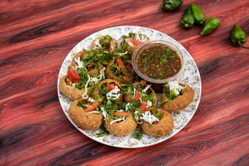 Fuchka, pan puri, or gol gappa filled with herbs with spicy water served in plate isolated on wooden table side view of bangladeshi street food © Food Shop