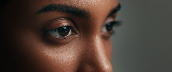 Eyes, face and skincare with a woman on a gray background in studio closeup for cosmetics. Beauty,...