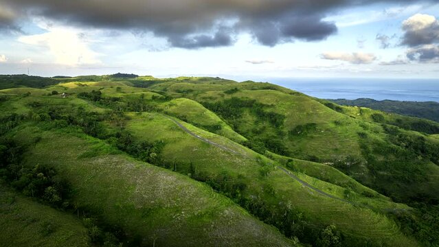 Hills with cloudy sky, Nusa Penida, Bali in Indonesia. Aerial forward. Hyperlapse time-lapse