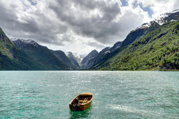 Obraz premium A boat floating in a Lovatnet lake with a mountain view