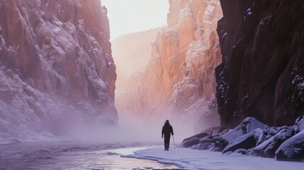 Hiker hiking in winter in rugged lands with snow.
