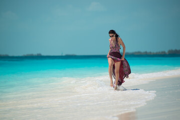 a girl in a dress and hat walks along the white sand, Siren beach in Cuba, Caribbean sea, palm trees on the beach, ocean shore,