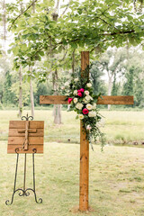 Wooden cross with floral arrangement in an outdoor setting