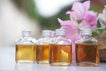 Transparent glass bottles of homemade herbal massage oil. Concept, Thai local wisdom to use fragrant medicinal herbs to make  massage oil for aromatherapy and relaxation.                      