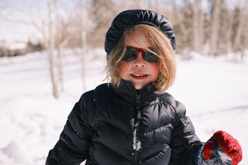 Child enjoying winter day in snowy outdoor landscape
