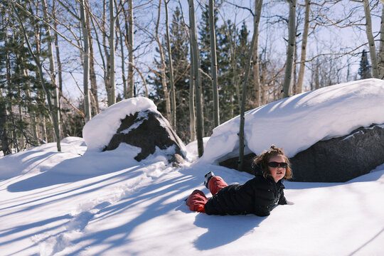Child playing in the snow in forest during winter