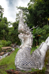 White Dragon statue at the base of a staircase in a buddhist temple