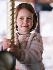 Smiling girl enjoying a carousel ride at an amusement park