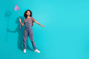 Photo of positive girl moving with fishnet look profile side isolated cyan color background