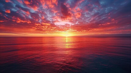 A breathtaking sunrise over a vast ocean, with the sky painted in hues of orange, pink, and purple.