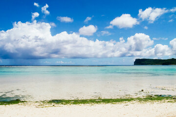Fototapeta premium Scenic view of fluffy white clouds over sandy Tumon Beach, Guam, USA