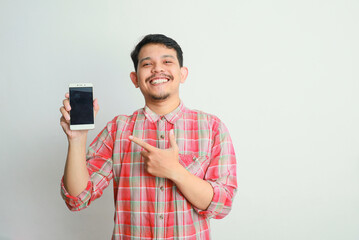 image of asian man holding phone, isolated on grey background. advertising concept.