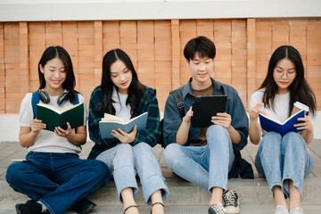 Young Asian People college students and a female student group work at the campus park in morning with her friend