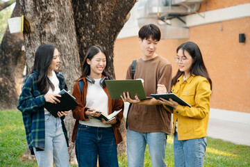 Young Asian People college students and a female student group work at the campus park in morning with her friend