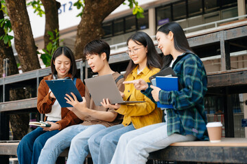 Young Asian People college students and a female student group work at the campus park in morning...