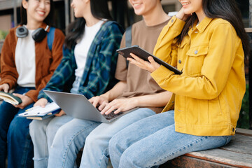 Young Asian People college students and a female student group work at the campus park in morning with her friend