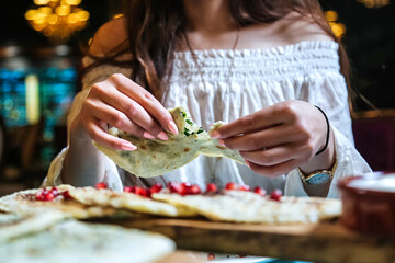Woman in White Top Eating a Tortilla