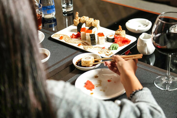 Woman Sitting at Table With Plate of Sushi