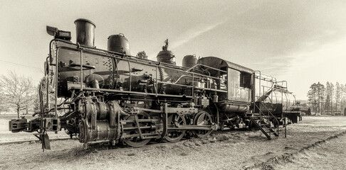 Antique locomotive rests on rural railroad tracks