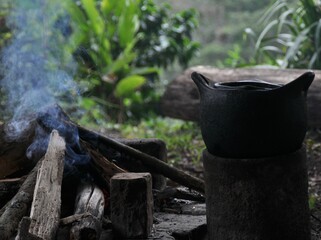 Olla de barro negra al lado de fogón