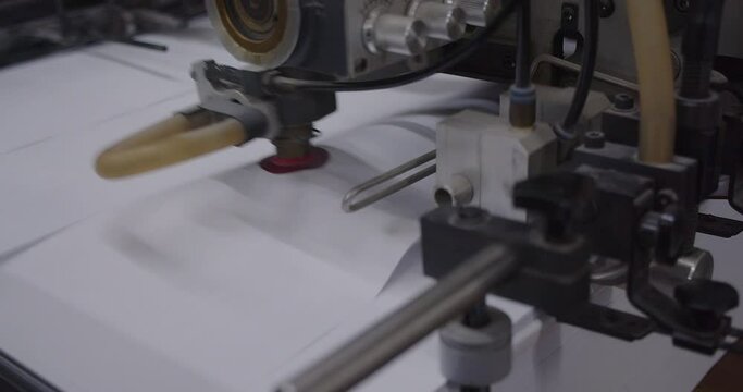 Closeup footage of an offset printing machine in printing house with blur background