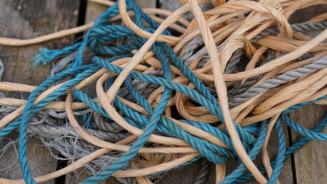 Closeup shot of messy rope and string entangled on a wooden surface