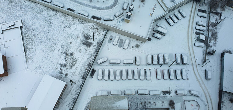 Winter's Embrace: Aerial View of Snow-Covered Parking Lot