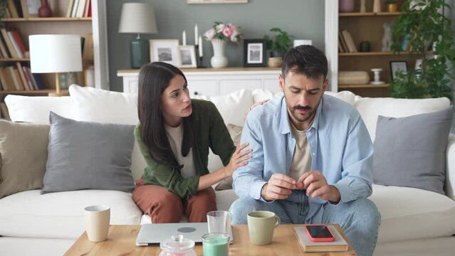Young woman trying to comfort and talk with the man to solve the problems. Relationship difficulties. Insulted and angry husband dont want to talk to his wife after argue.