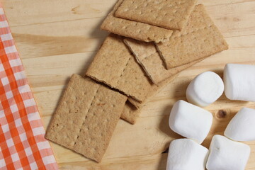 a wooden table topped with grahamy treats and marshs
