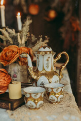 Table set with vintage coffee cups, saucers, and golden teapot