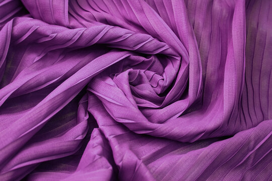 Purple satin fabric draped over a table cloth