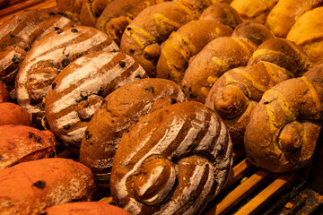Closeup shot of a variety of breads and pastries displayed on a bakery shelf