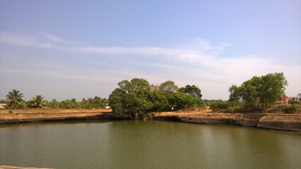 Fototapeta premium Lake with blue skies in the background in rural Kerala, India