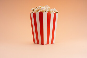 Striped popcorn bucket on a tan background.