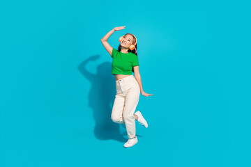 Full body portrait of pretty young girl dance headphones wear t-shirt isolated on turquoise color background