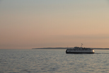 Ferry leaving the harbor of Woods Hole on Cape Cod on a trip to Marthas Vineyard at sunset