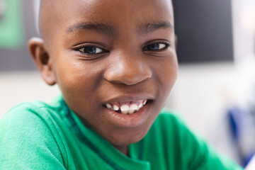 In school, young African American boy is smiling at camera in the classroom