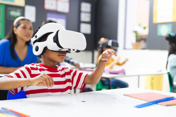 In school, in the classroom, a diverse group is exploring virtual reality, copy space